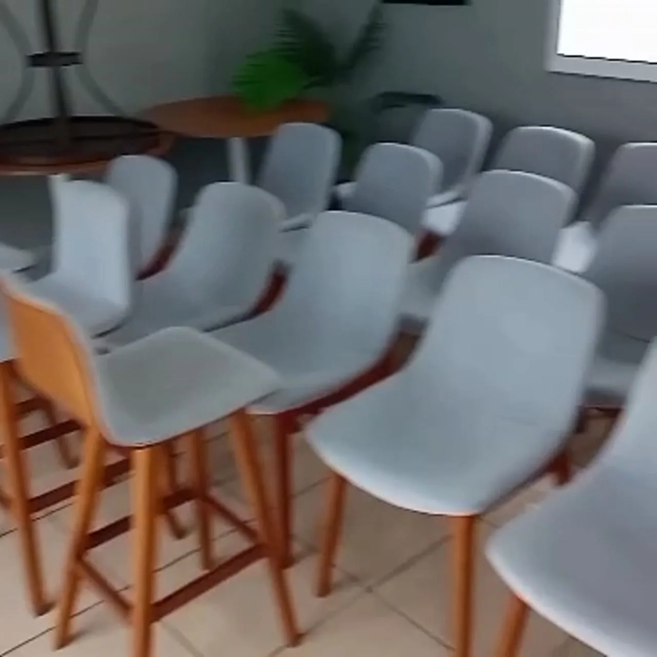 Cadeiras e banquetas estofadas cinza em um salão